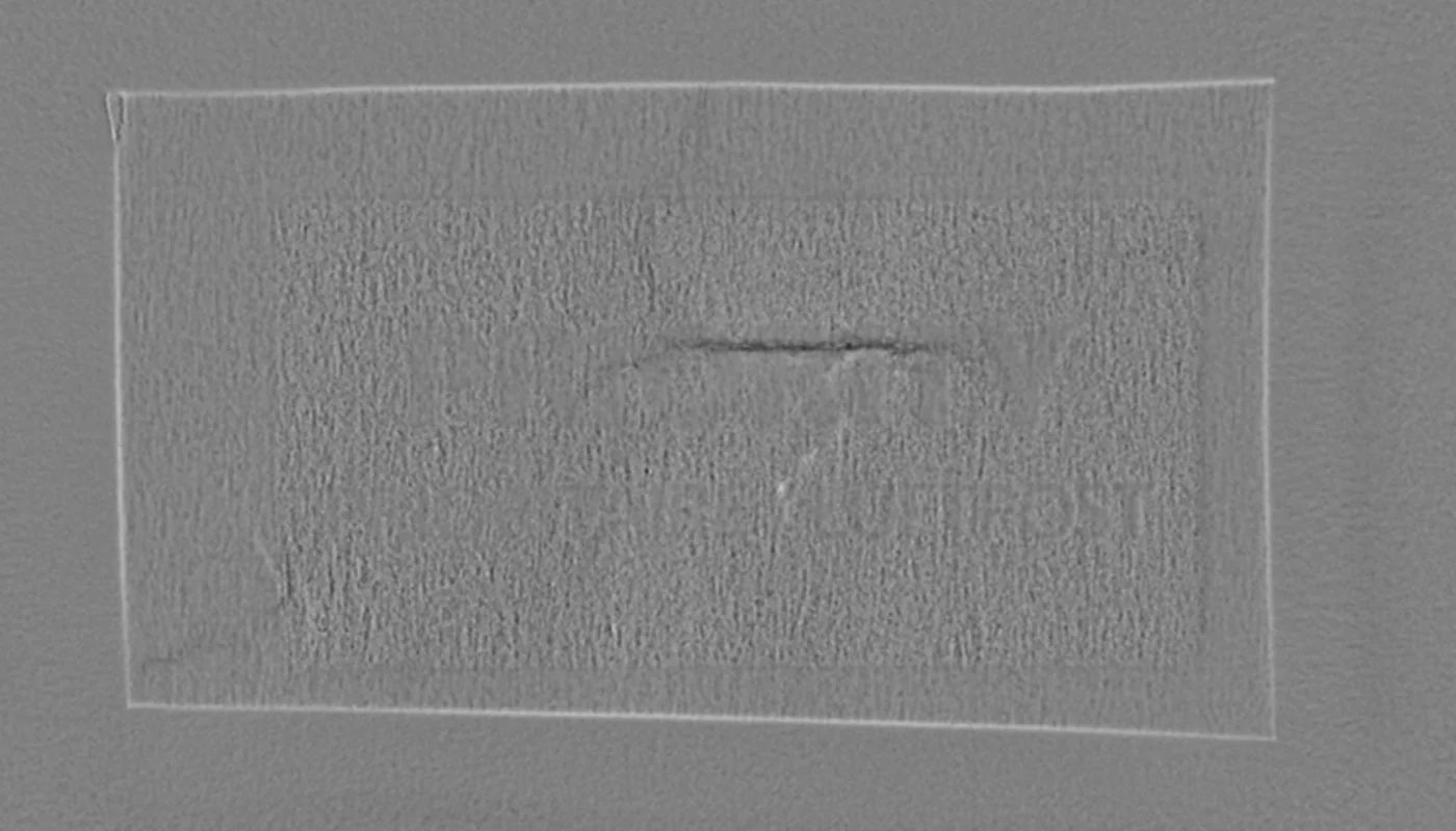 Ein Knick in einem bedruckten Etikett, von beiden Seiten des Papiers – Relief, vorn